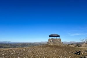 The Mushroom: a round shelter structure set against a blue sky and Lake District mountains.